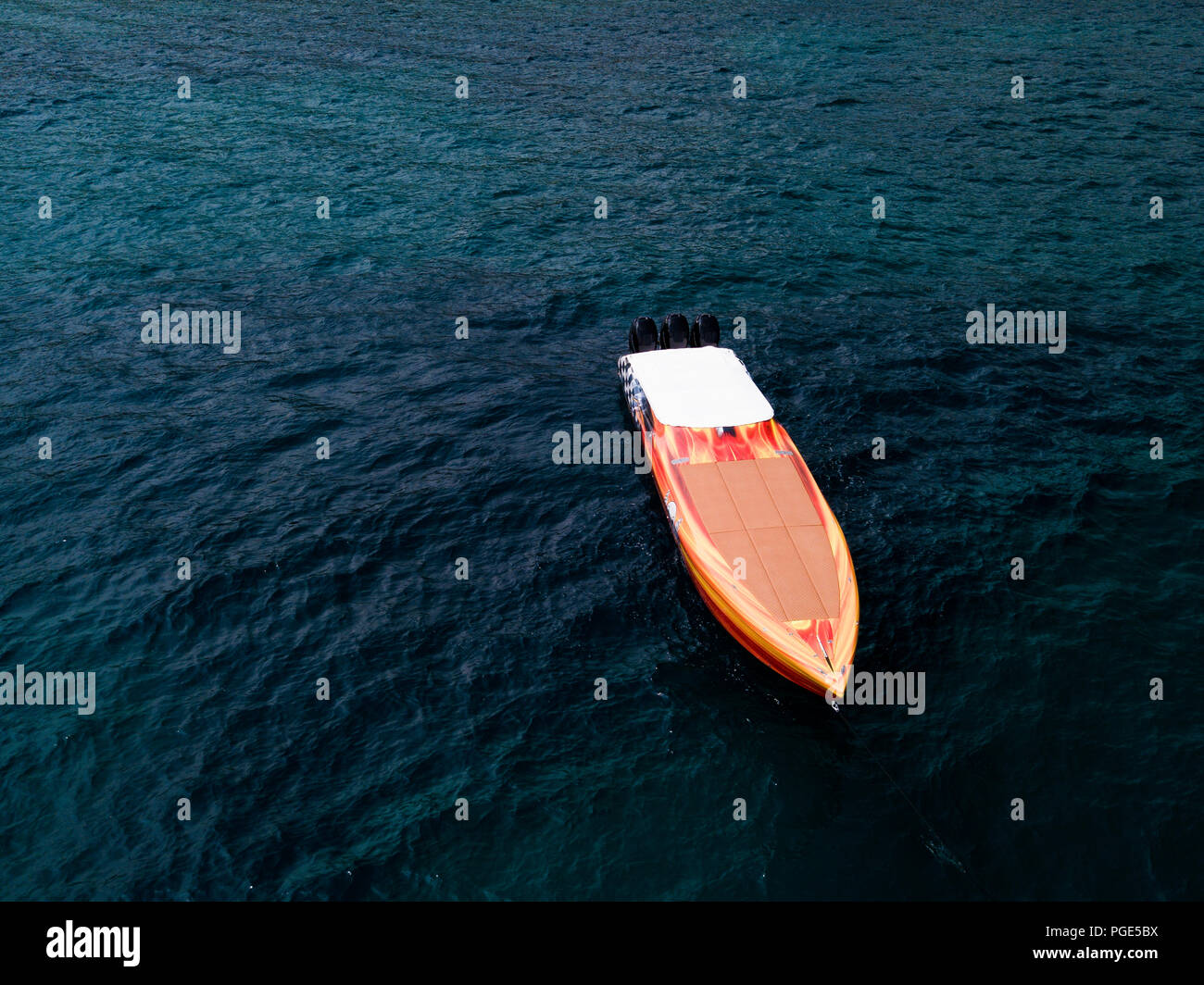 Vue aérienne d'une belle course orange bateau naviguant sur une mer turquoise et transparente. Sardaigne, Italie. Banque D'Images