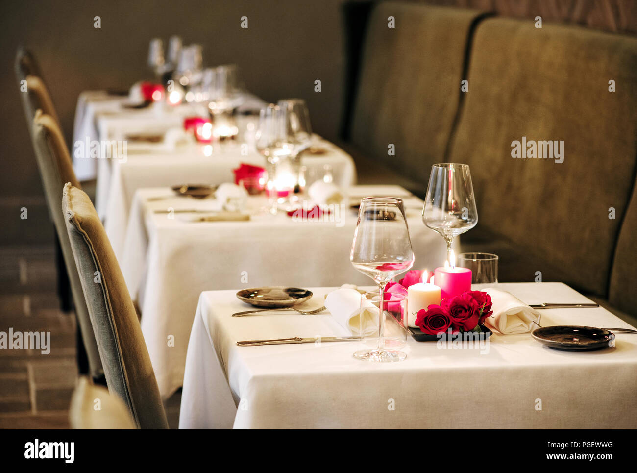 Paramètres tableau romantique dans un restaurant avec table de brûler des  bougies et des roses rouges et verrerie élégante pour un dîner intime pour  deux Photo Stock - Alamy