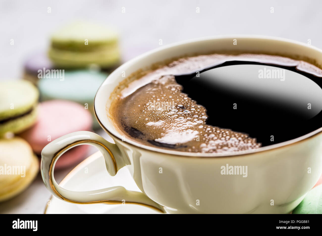 Tasse de café noir avec macarons français. Banque D'Images