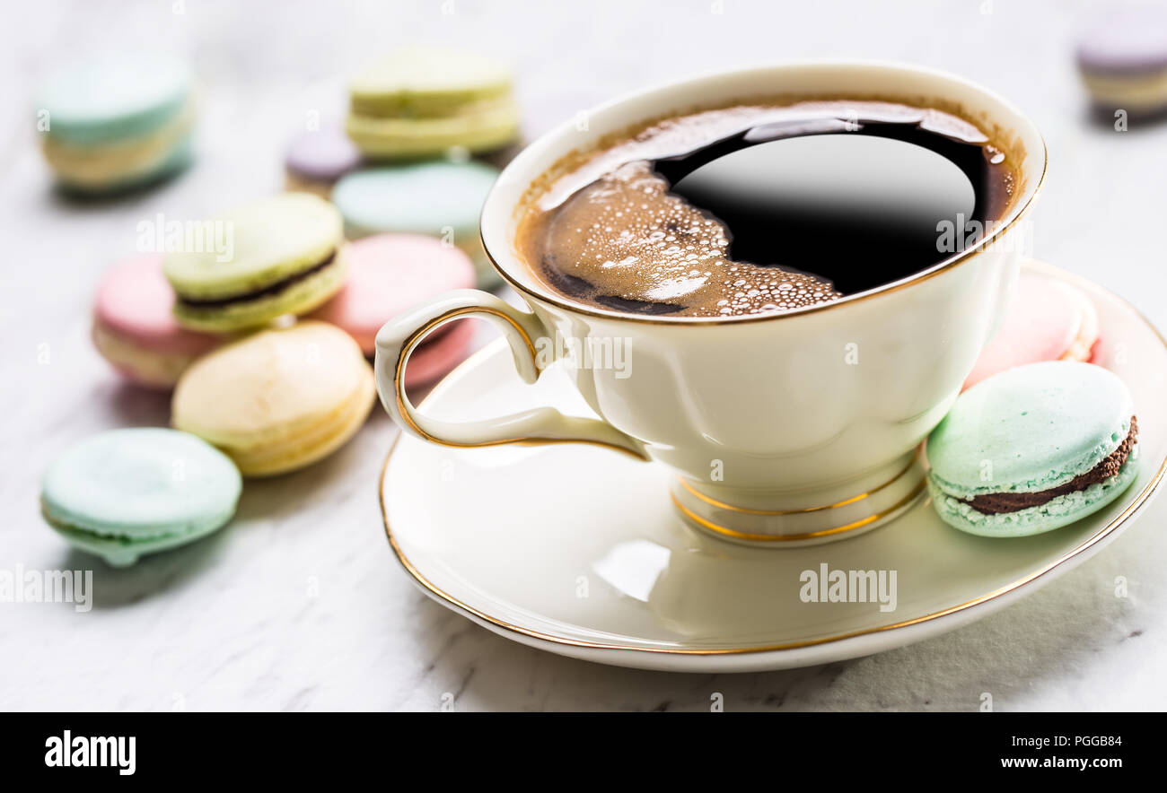 Tasse de café noir avec macarons français. Banque D'Images