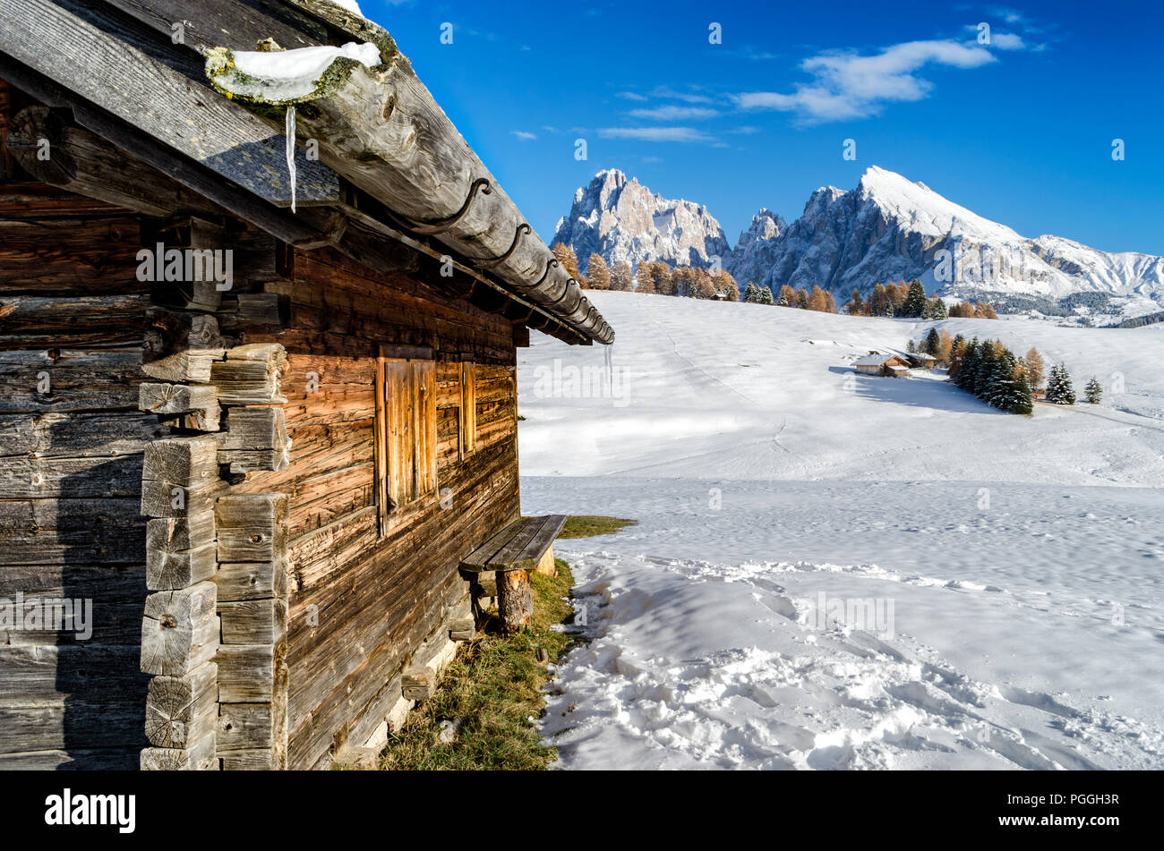 Chalet en bois dans la neige avec une vue sur la montagne Dolomites Langkofel pointe sur l'Alpe di Siusi, le Tyrol du Sud, Italie. Banque D'Images