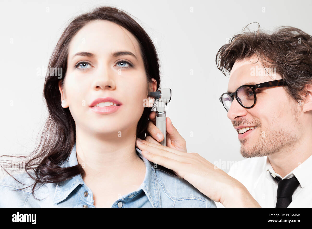 Médecin oto-rhino-laryngologie de l'Inspection du canal auriculaire et du tympan lors d'un examen ORL Banque D'Images