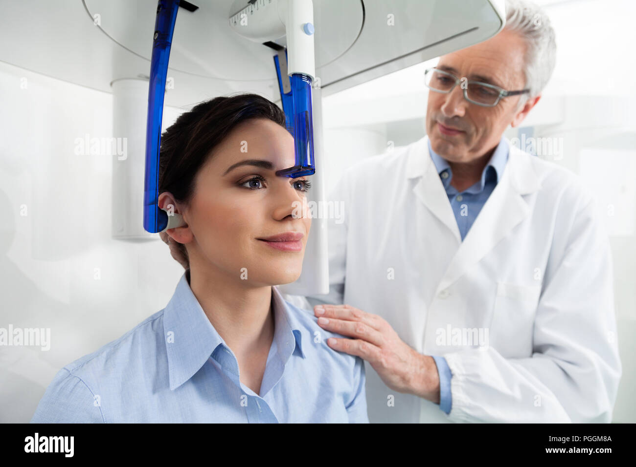 Young woman portrait ayant une vue panoramique sur la radiographie numérique de ses dents avec un médecin d'âge moyen dans le cabinet dentaire. Banque D'Images