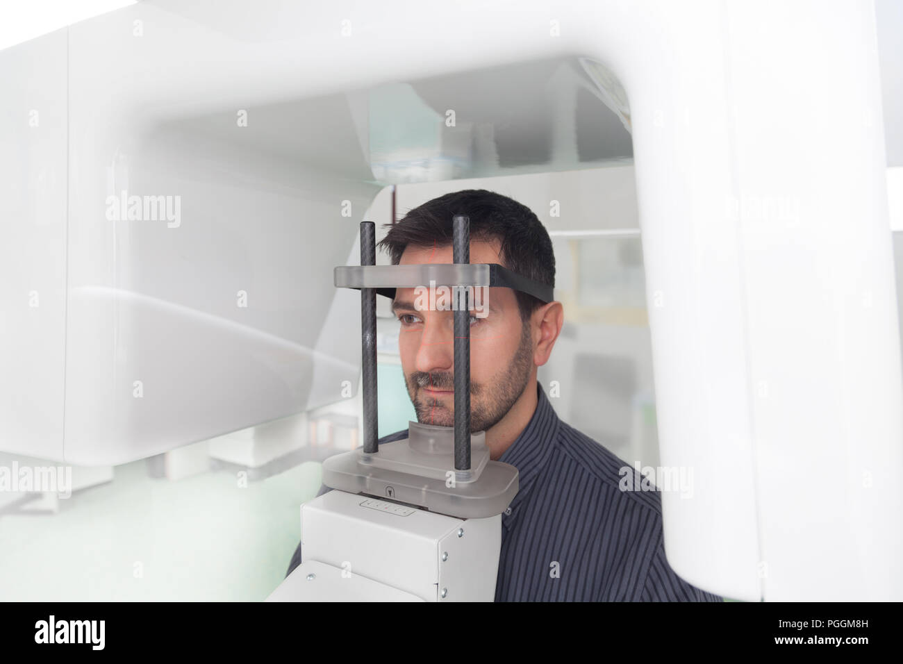 Portrait jeune homme ayant une vue panoramique sur la radiographie numérique de ses dents dans le cabinet dentaire. Banque D'Images