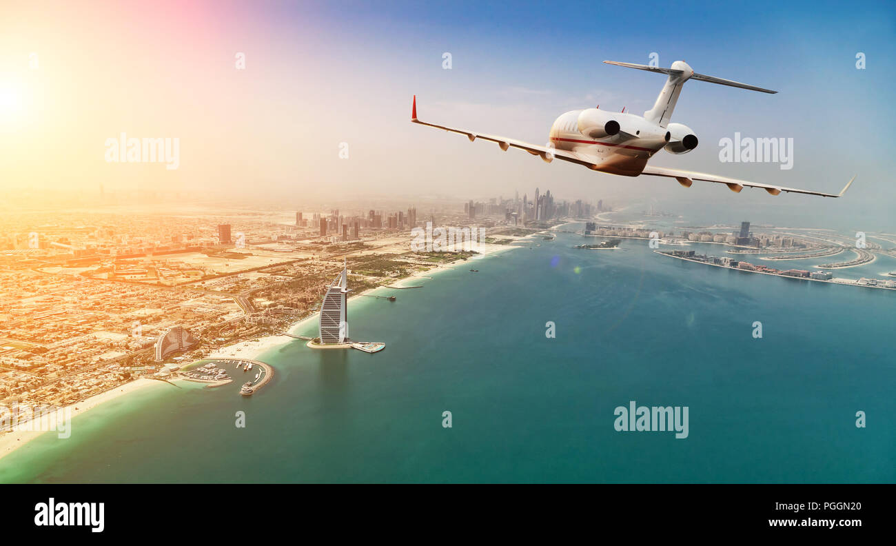 Jet Privé avion volant au-dessus de la ville de Dubaï en beau coucher de la lumière. Hôtel moderne et le mode de transport le plus rapide, la vie de l'entreprise. Banque D'Images