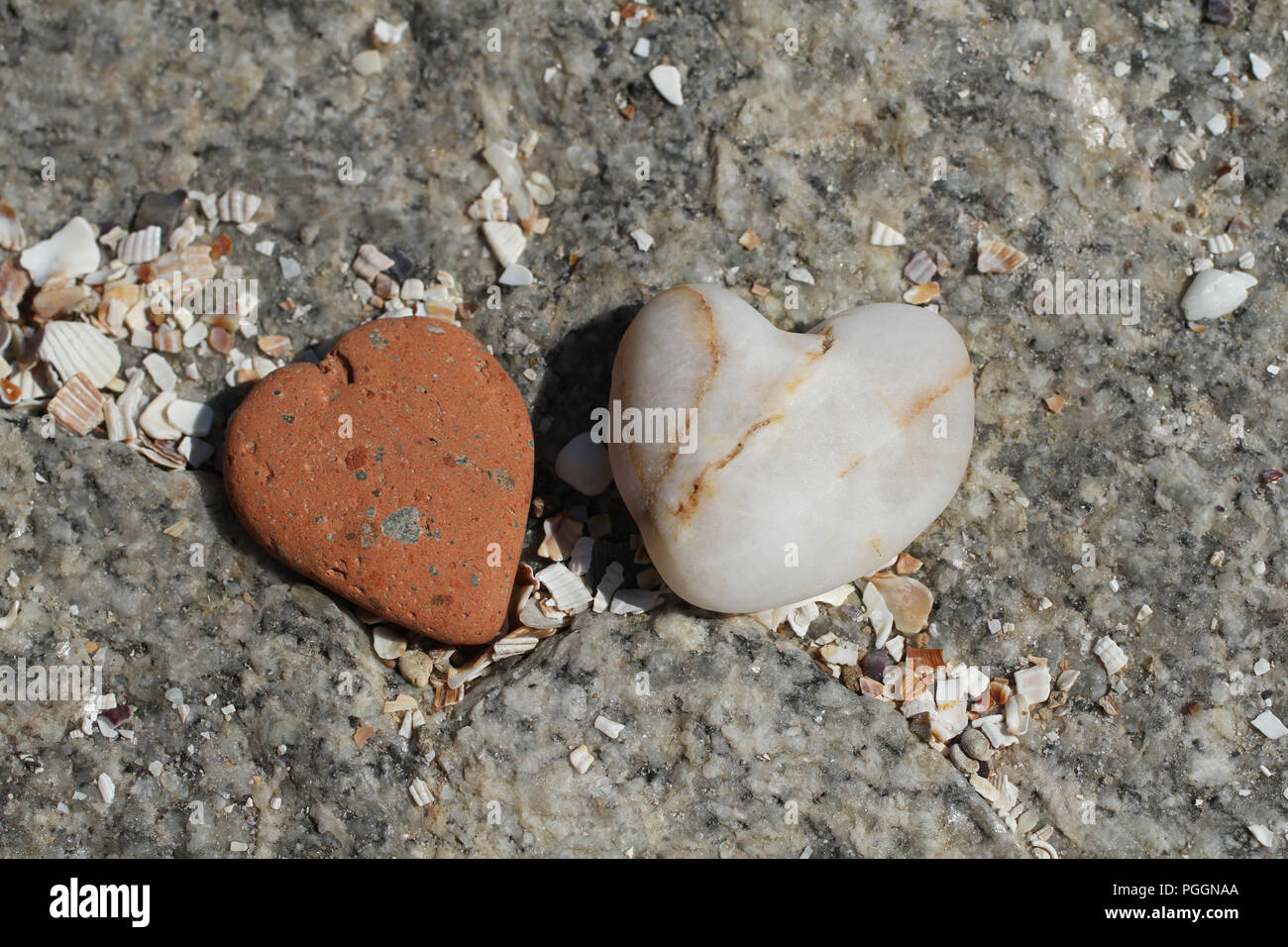 Deux pierres en forme de coeur allongé sur big pierre grise. Libre Banque D'Images