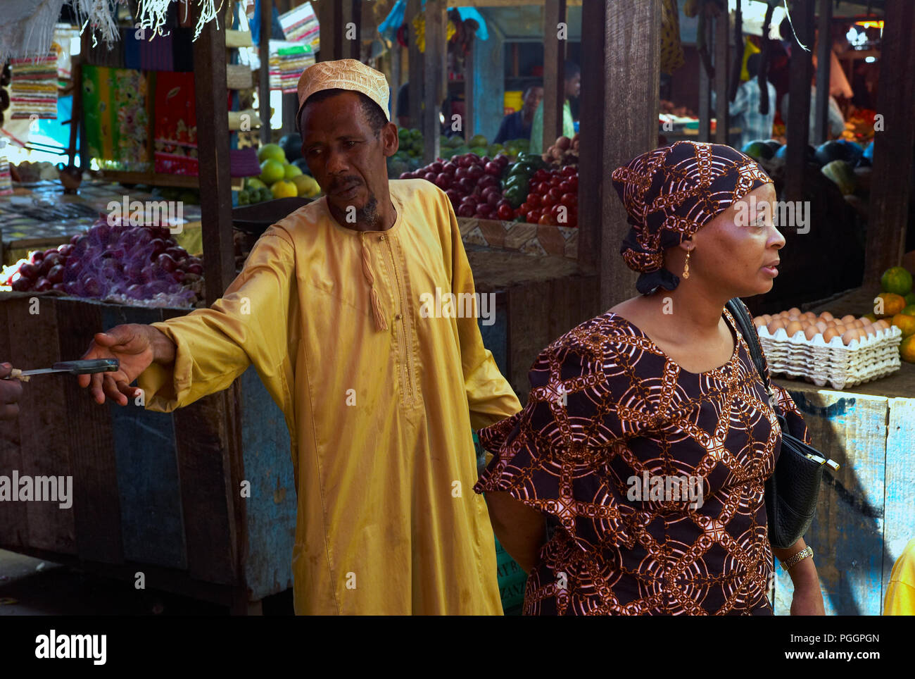 STONE Town, Zanzibar, Tanzanie - 06 juillet 2008 : Un vendeur atteint pour un couteau sur un marché à Stone Town, Zanzibar. Banque D'Images