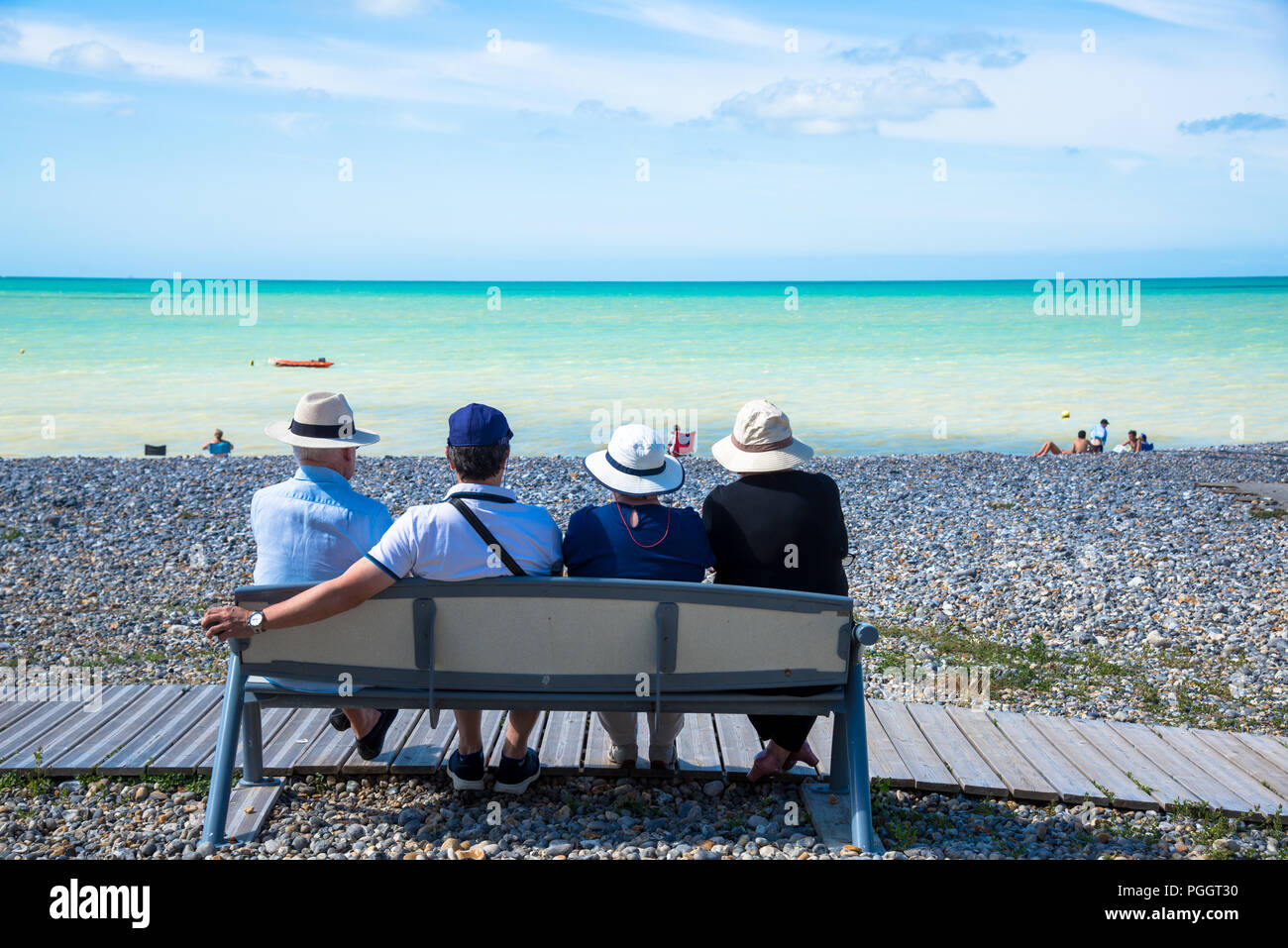 Personnes sur un banc face à la mer à Criel sur Mer en Normandie, France Banque D'Images