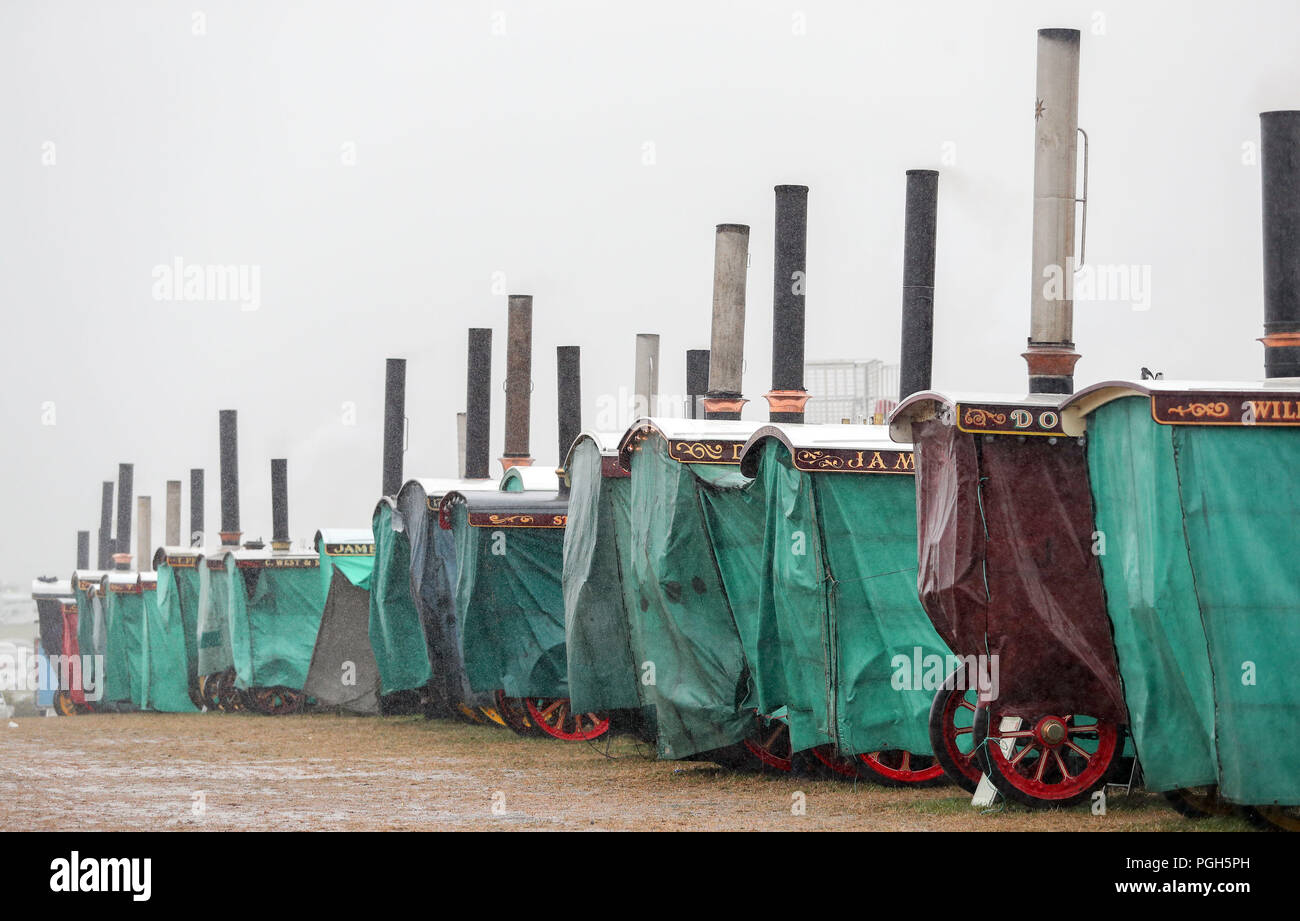 Les moteurs de traction à vapeur sous couvre comme une douche de pluie passe au-dessus de la Grande Vapeur Dorset, juste à Blandford, Dorset, où des centaines de moteurs de traction à vapeur période lourde et l'équipement mécanique de toutes les époques se sont réunis pour la foire annuelle pour célébrer le 50e anniversaire de l'émission. Banque D'Images