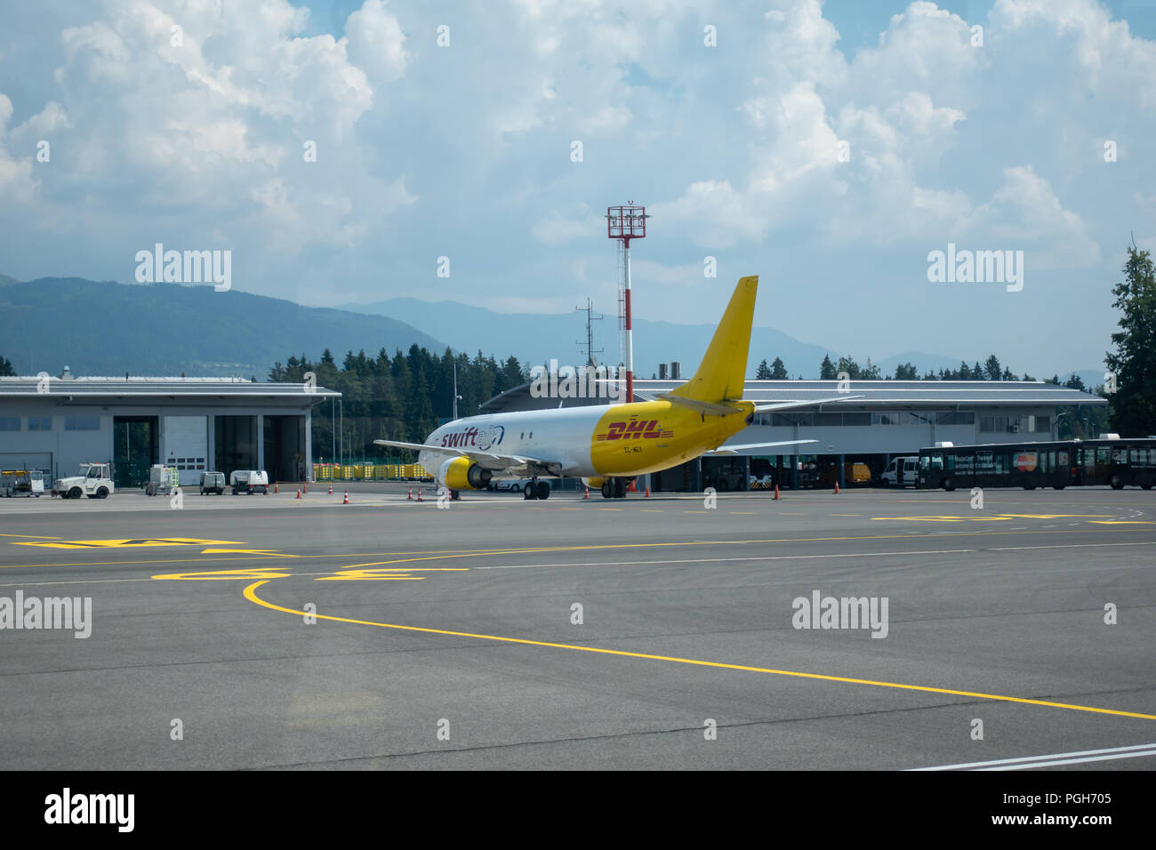Brnik, Slovenija - 23 août 2018 : Swift Air Boeing B737 jaune avec logo DHL sur la queue à l'aéroport de Ljubljana en attente de chargement sur tarmac. Banque D'Images