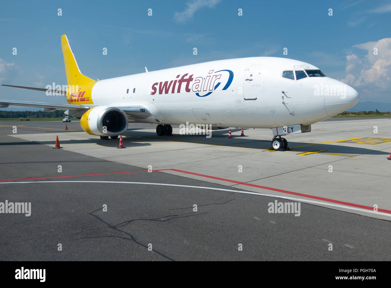 Brnik, Slovenija - 23 août 2018 : Swift Air Boeing B737 jaune avec logo DHL sur la queue à l'aéroport de Ljubljana en attente de chargement sur tarmac. Banque D'Images