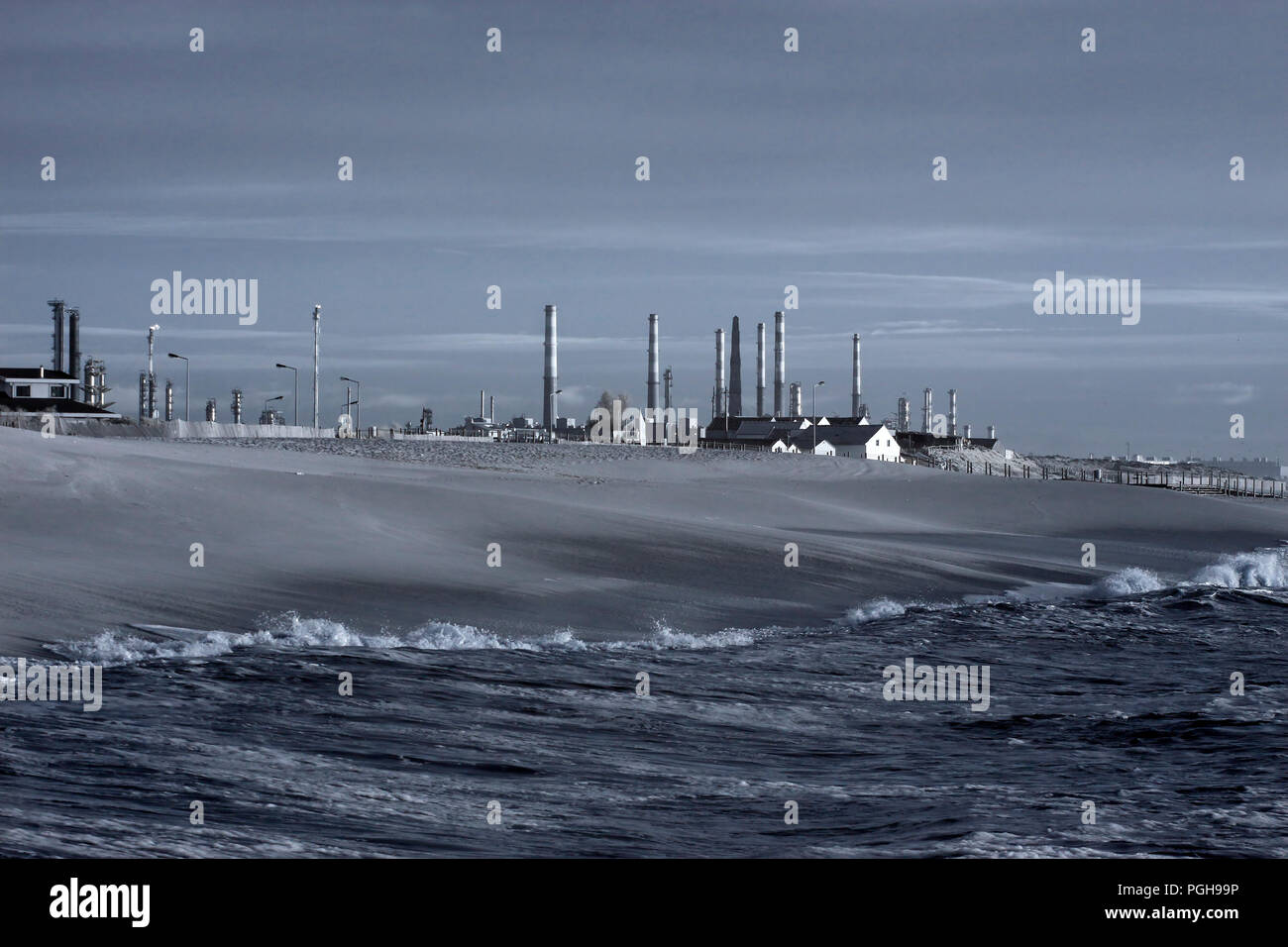 Raffinerie de pétrole par la mer. Fin de la journée. Utilisé filtre infrarouge. Blue Toned Banque D'Images