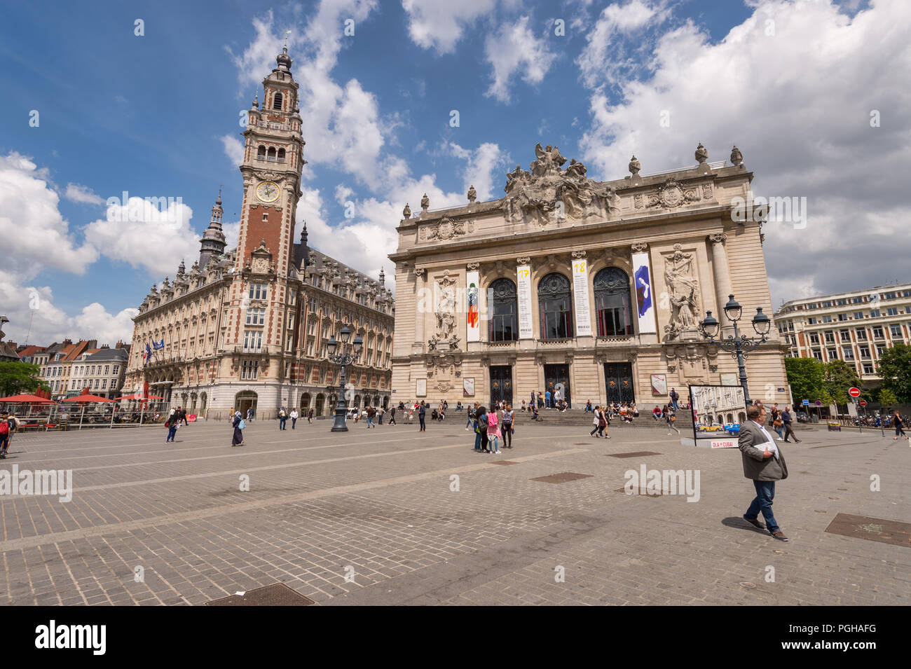 Lille, France - 15 juin 2018 : Les gens qui marchent dans la place du théâtre. Beffroi de la Chambre de Commerce et de l'Opéra en arrière-plan. Banque D'Images