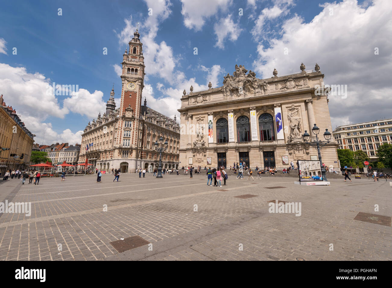 Lille, France - 15 juin 2018 : Les gens qui marchent dans la place du théâtre. Beffroi de la Chambre de Commerce et de l'Opéra en arrière-plan. Banque D'Images