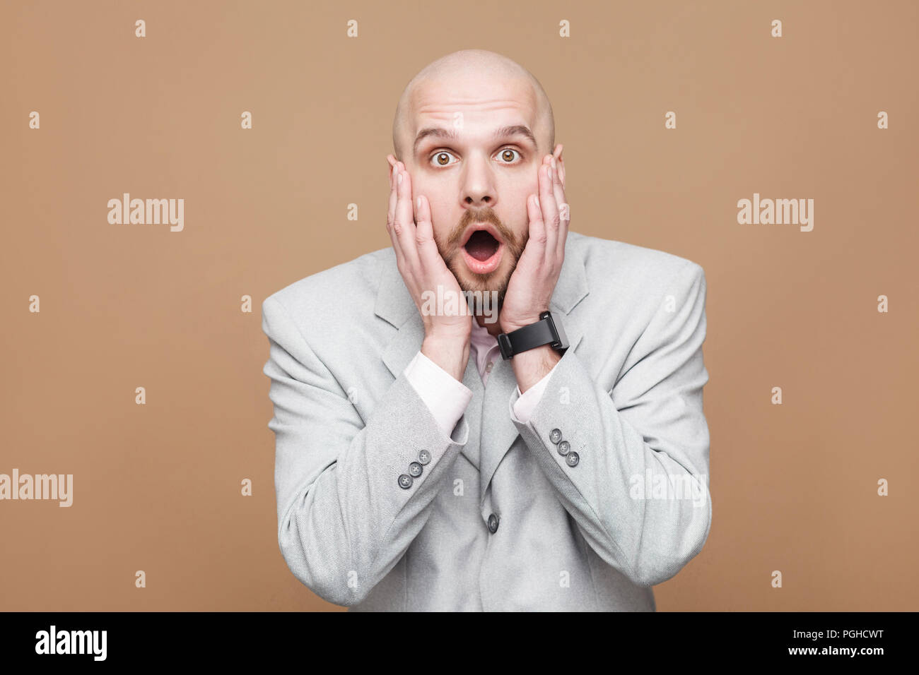Wow, son incroyable. Portrait de surpris handsome middle aged businessman en costume gris lumière debout, tenant la main sur le visage et looking at camera wifi Banque D'Images Wow, son incroyable. Portrait de surpris handsome middle aged businessman en costume gris lumière debout, tenant la main sur le visage et looking at camera wifi Banque D'Images