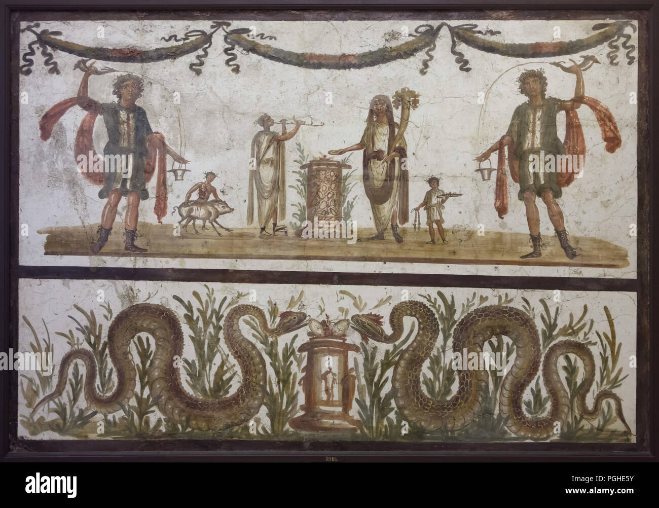 Sacrifice scène représentée dans la fresque romaine de Pompéi, aujourd'hui exposées dans le Musée Archéologique National (Museo Archeologico Nazionale di Napoli) à Naples, Campanie, Italie. Deux lares, dans leurs vêtements caractéristique et constitue, pour le vin de l'rython (corne potable romain) dans la situle - godet). Ils se tiennent de chaque côté d'une scène de sacrifice, effectuée par le génie assisté de fonctionnaires et un musicien avec double-flûte. Sous la scène une paire de serpents, apportent de la prospérité et l'abondance, ont atteint l'offre d'oeufs placés sur un autel. Banque D'Images