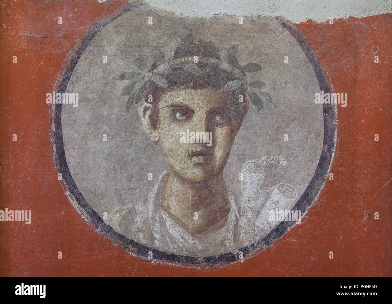 Médaillon avec un homme portrait d'un jeune poète décerné une guirlande d'avoir pris part à un concours littéraire représenté dans la fresque romaine de la maison du Cénacle (Casa del Cenacolo) à Pompéi (1-79 MA), maintenant exposée dans le Musée Archéologique National (Museo Archeologico Nazionale di Napoli) à Naples, Campanie, Italie. Il a contribué d'une composition de caractère philosophique depuis Platon, peut être lue sur l'étiquette de nom pendant du rouleau. Banque D'Images