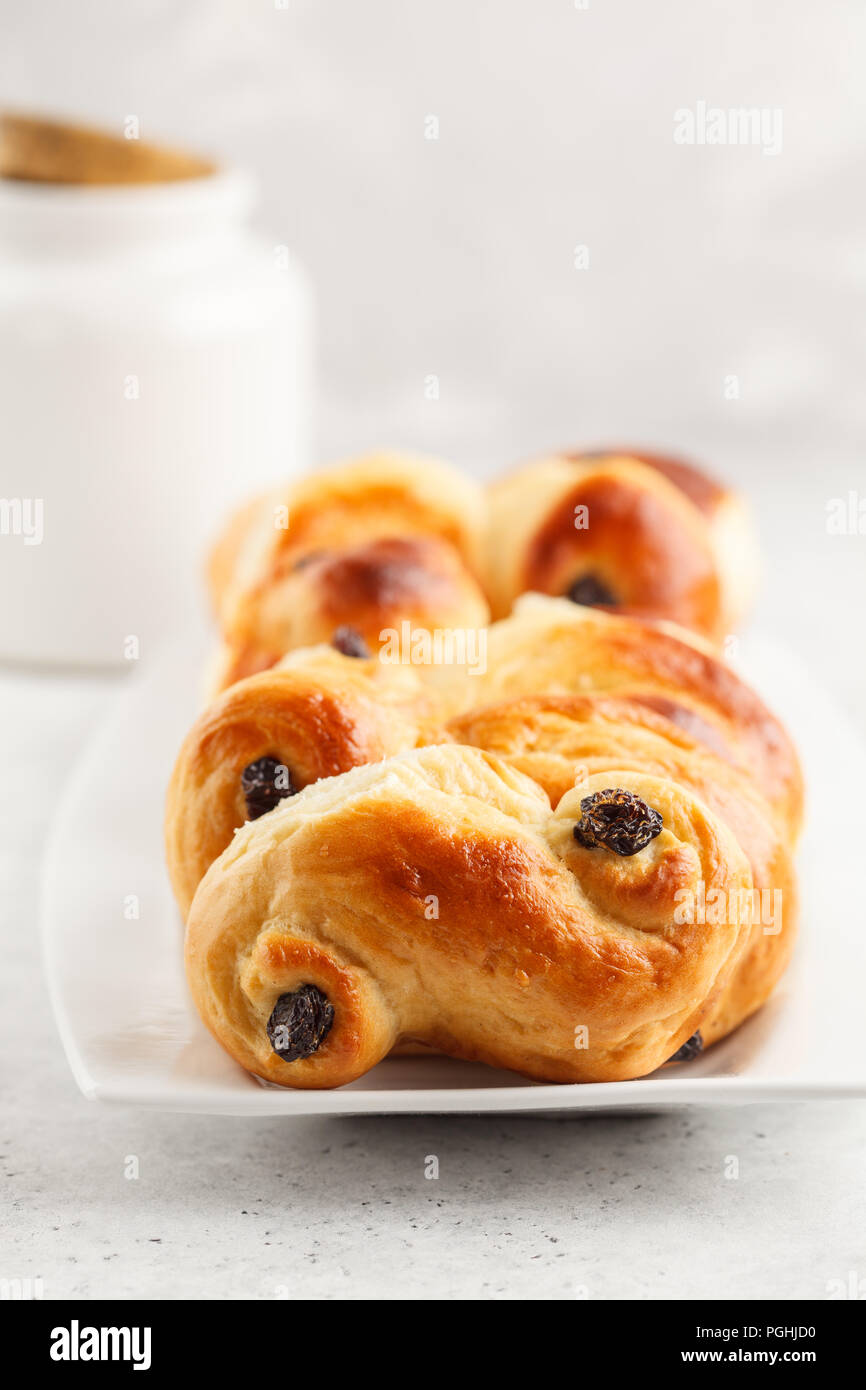 Petits pains au safran traditionnel suédois (lussebulle ou lussekatt), fond blanc, petit déjeuner européen. Banque D'Images