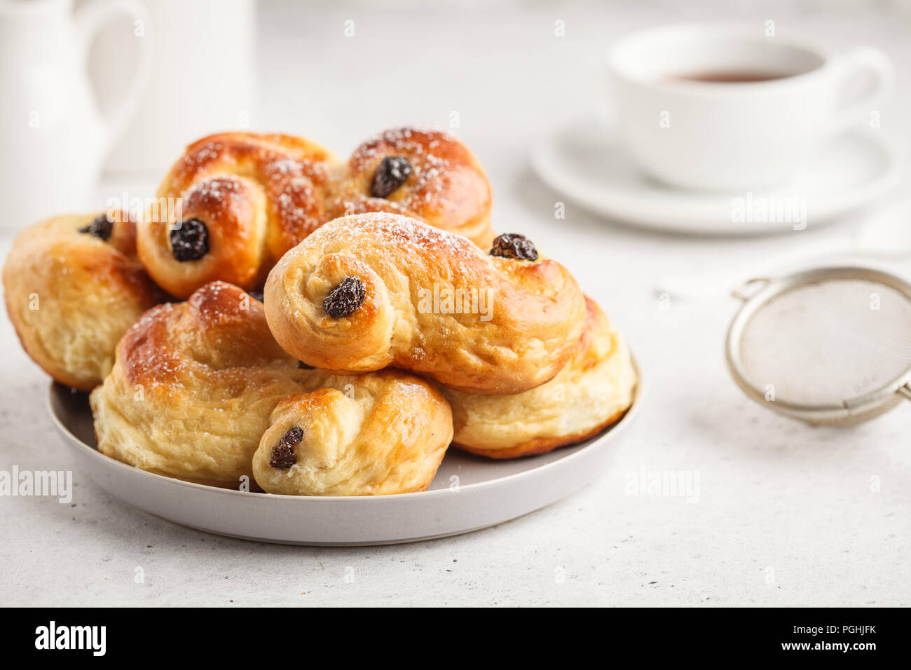 Petits pains au safran traditionnel suédois (lussebulle ou lussekatt), fond blanc, petit déjeuner européen. Banque D'Images