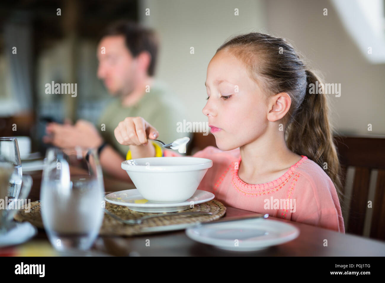 Adorable petite fille qui mange son petitdéjeuner à la maison ou au