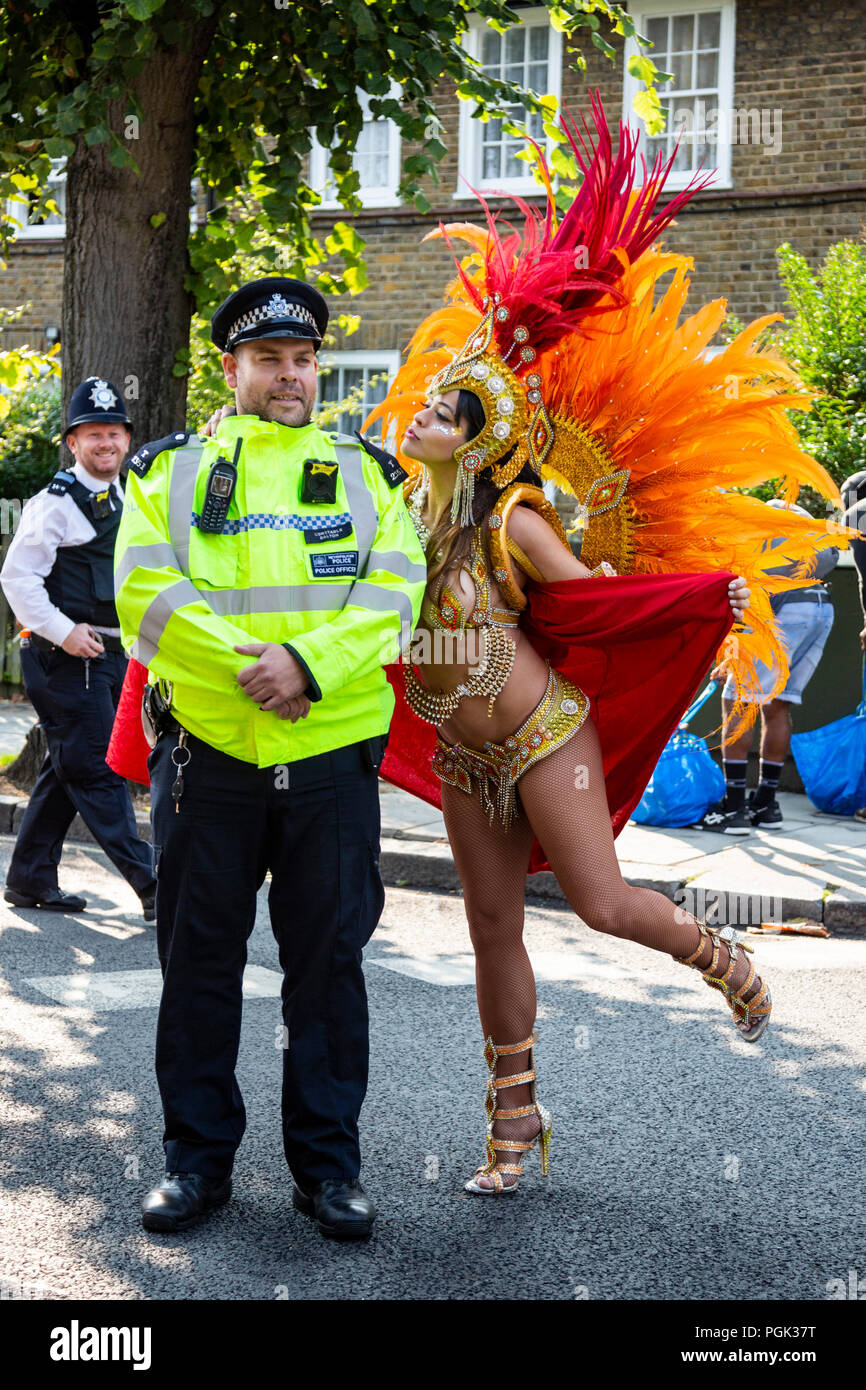 Londres, Royaume-Uni. 27 août 2018. Un danseur de l'école de samba Paraiso pose avec un policier, avant le défilé à Notting Hill Carnival, la plus grande partie de la rue. Photo : Bettina Strenske/Alamy Live News Banque D'Images