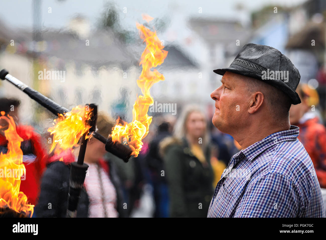 Ballycastle, Irlande du Nord. Lundi 27 Août, 2018. Un artiste de rue jongle avec des torches enflammées à l'Ould Lammas Fair à Ballycastle Le Ould Lammas Fair est la plus ancienne foire de l'Irlande. Le mot Lammas vient de 'la masse' - Pain pain cuit traditionnellement à partir de la première les grains d'automne ont été mis sur l'église à modifier. SSince le 17ème siècle, l'traders affluent sur la juste d'acheter et de vendre des animaux, une tradition qui continue Crédit : Graham de Alamy Live News Banque D'Images