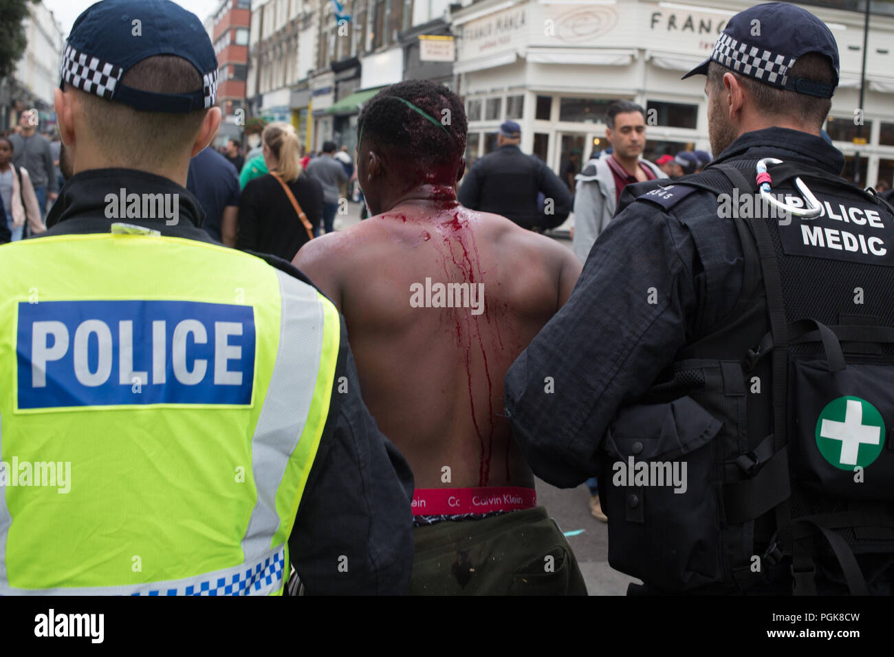 London UK 27 août 2018 conduire un homme à l'écart par la police après avoir été poignardé à Notting Hill Carnival.. Credit : Thabo Jaiyesimi/Alamy Live News Banque D'Images