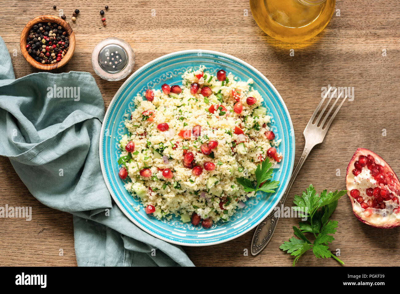 Taboulé salade de couscous avec graines de grenade servi sur plaque turquoise traditionnel. Arabe Banque D'Images