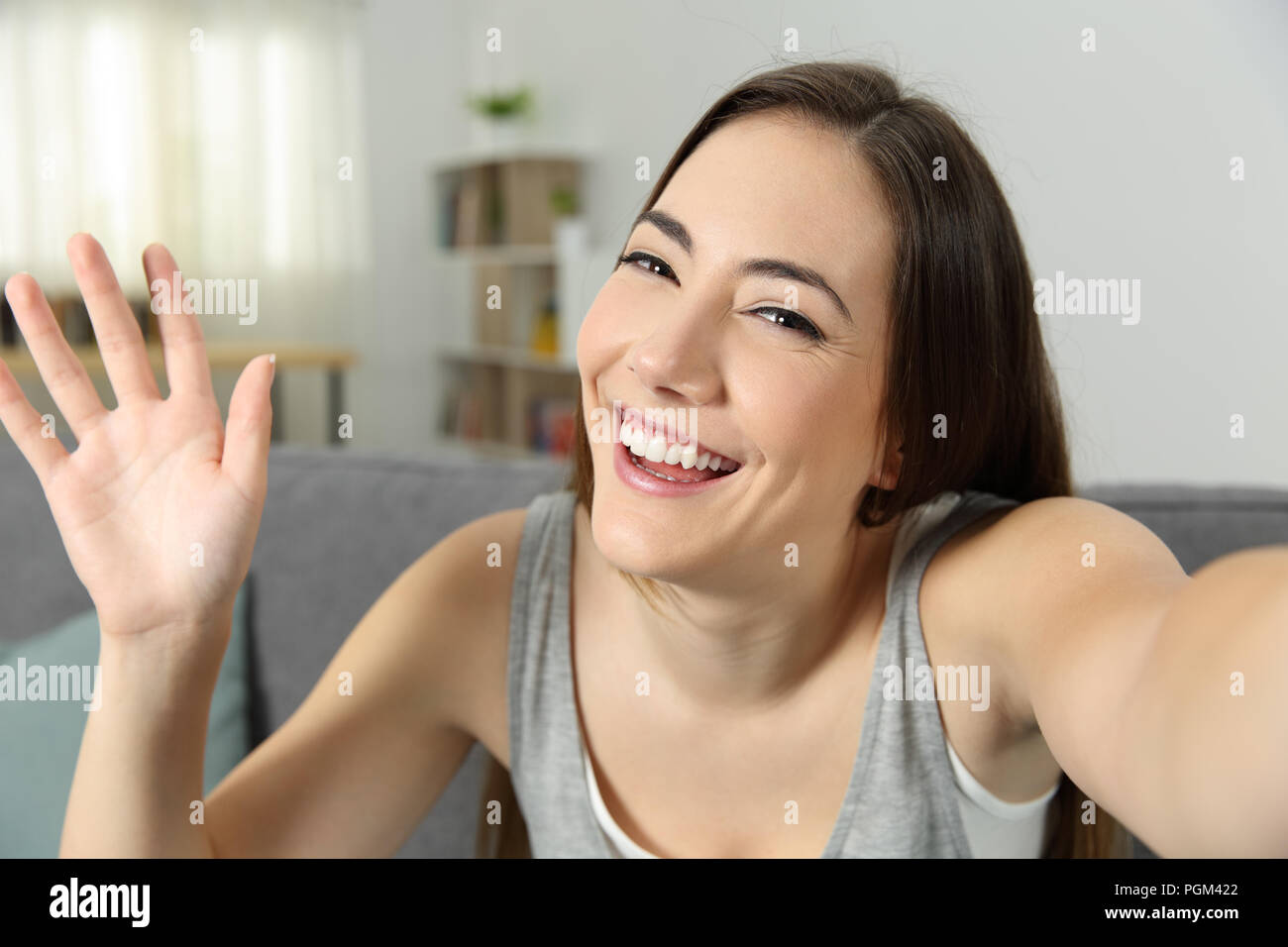 Portrait d'une fille en agitant l'enregistrement vidéo ou de prendre à la maison selfies Banque D'Images