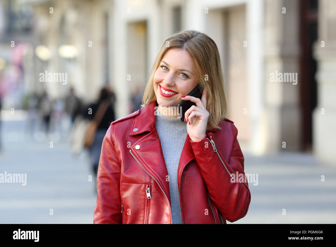 Fashion woman looking at camera phone marche dans la rue Banque D'Images