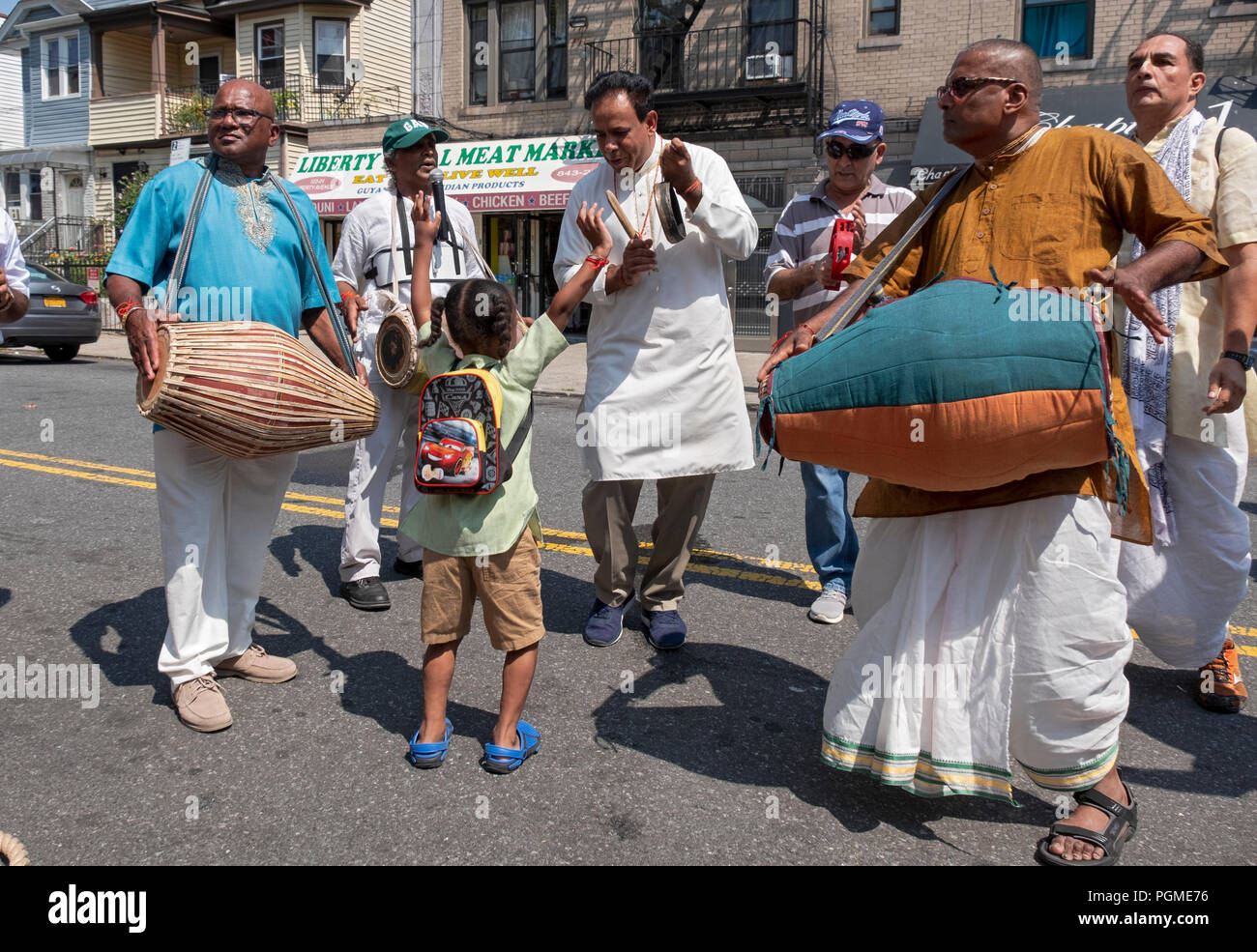 Une jeune fille hindoue allègrement des danses pendant que les musiciens jouent devant le Queens, New York 2018 rathayatra Parade. Banque D'Images