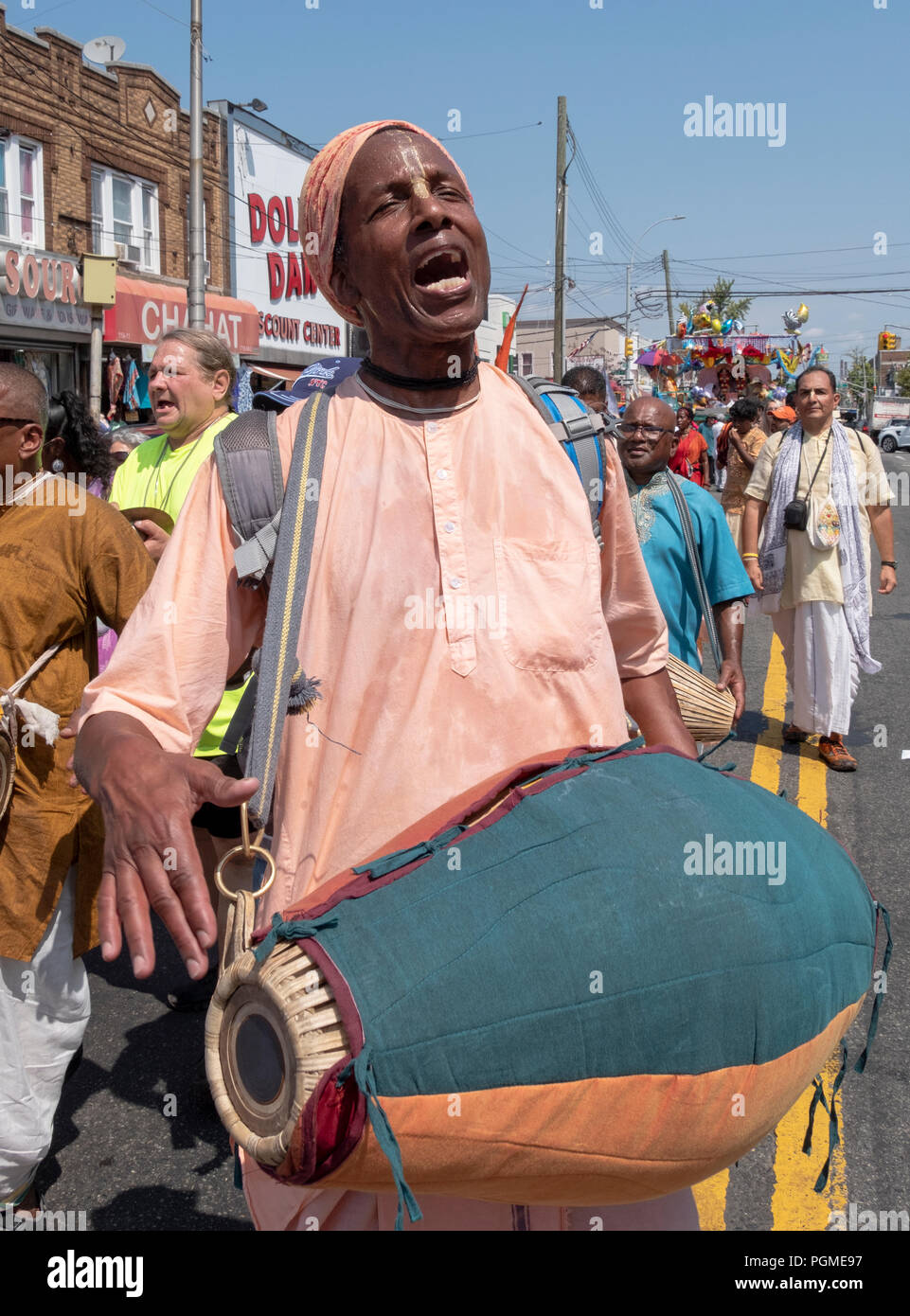 Un homme jouant le mrdanga hindou tambour indien au Queens, New York Rathayatra Parade. Banque D'Images