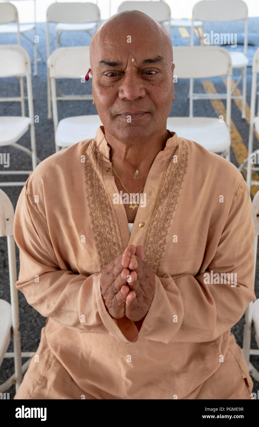 Un indien Pandit américain portant une fleur à l'oreille et une étoile de David autour du cou. Dans le Queens, New York. Banque D'Images