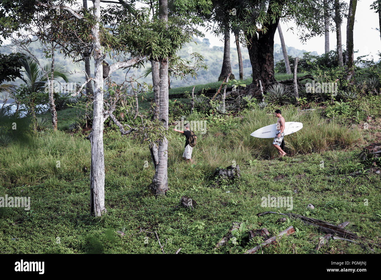 Les surfeurs à marcher le long du chemin panoramique de plage de Santa Catalina, Panama Banque D'Images