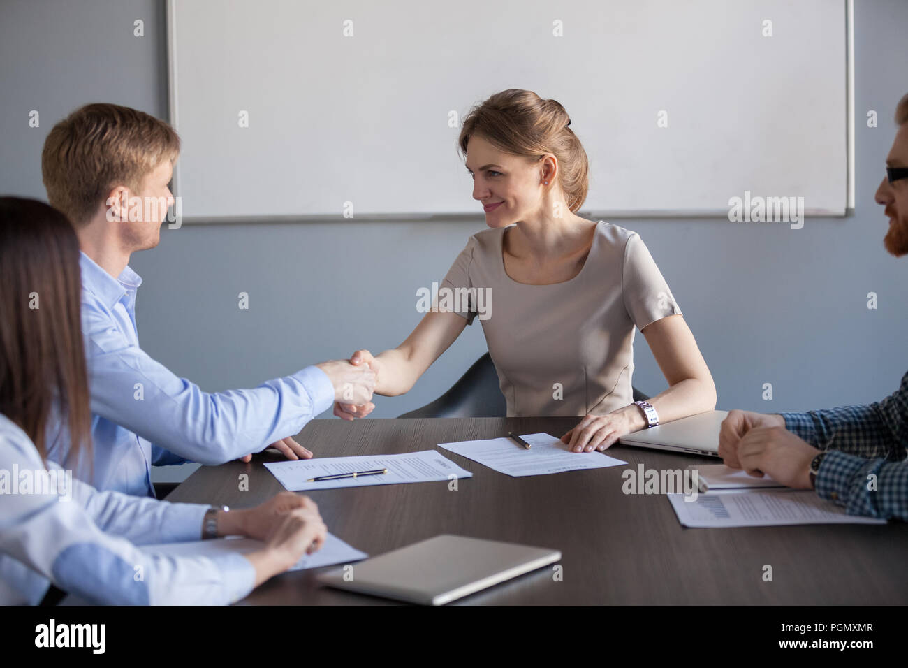 Poignée femelle businesswoman partenaire masculin après avoir signer de contrat Banque D'Images