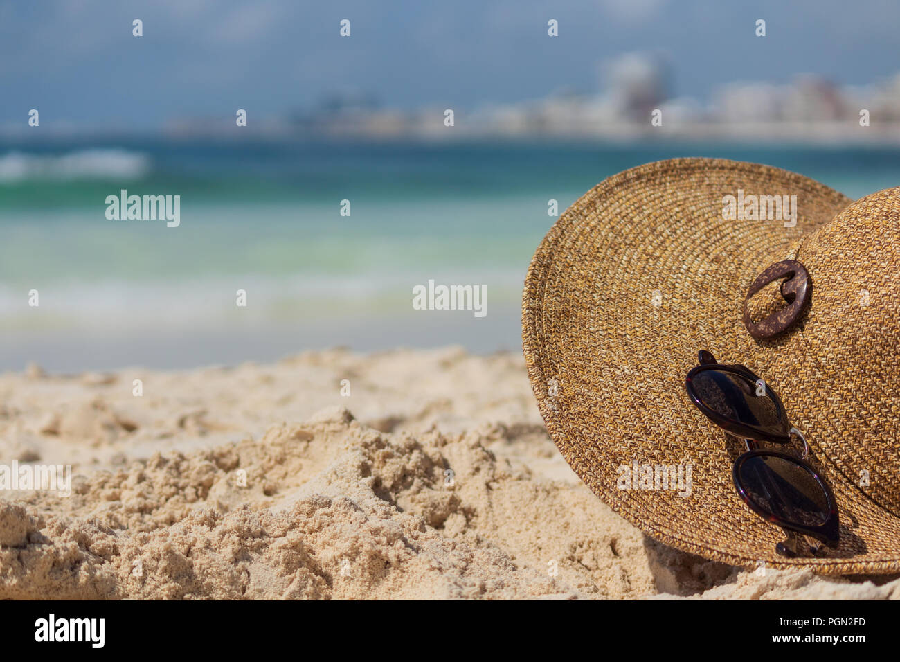 Aperçu de l'été. Chapeau et lunettes de soleil dans le sable. L'accent sur hat détails. Mer des Caraïbes, dans l'arrière-plan. Banque D'Images