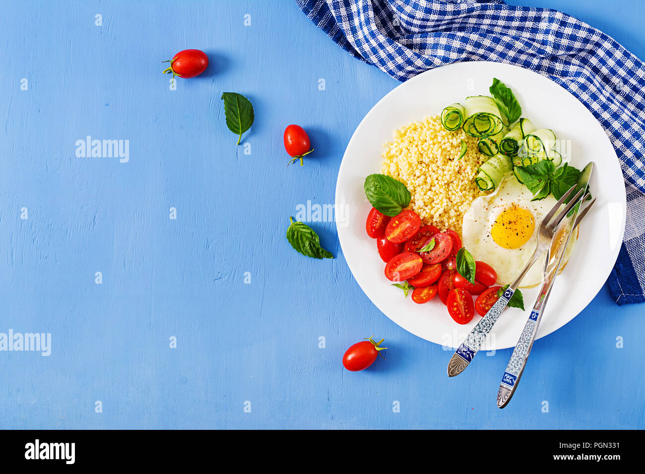 Petit déjeuner sain. Menu diététique. Porridge de millet et de tomates, salade de concombre et d'œufs au plat. Vue d'en haut. Mise à plat Banque D'Images
