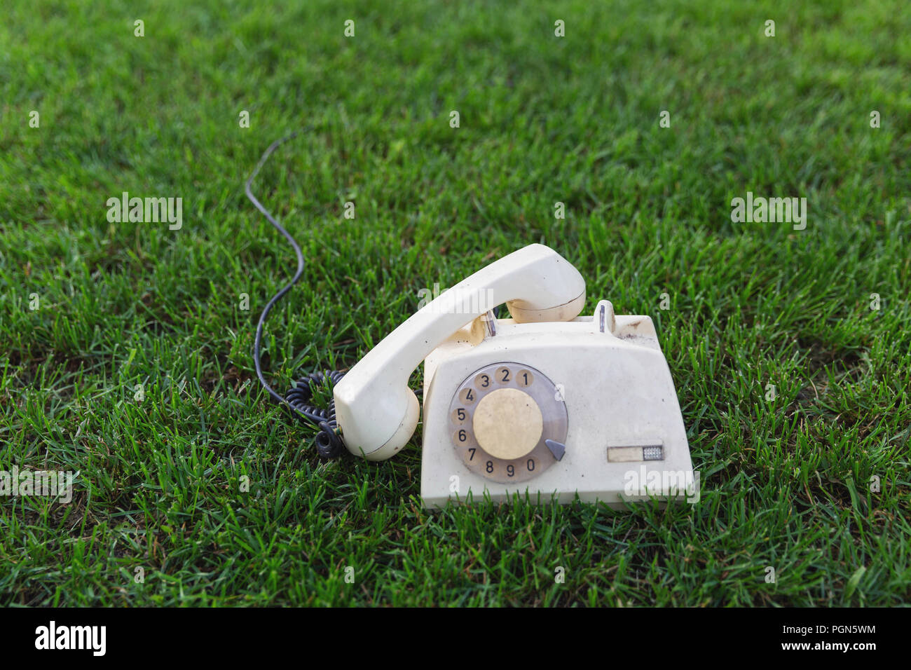 Ancienne rétro téléphone sur l'herbe verte Banque D'Images