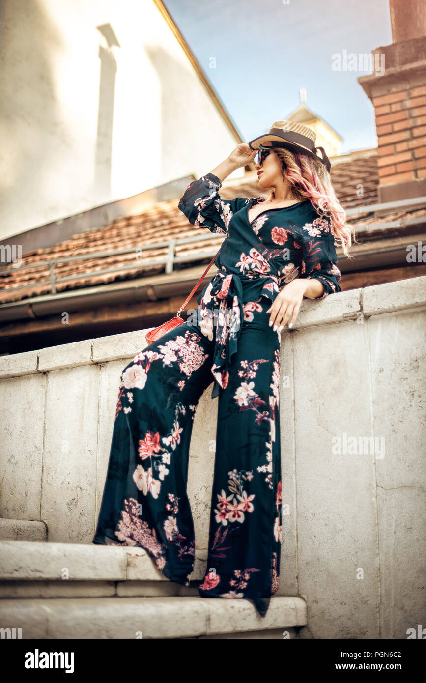 Belle Femme avec sac à main de mode sensuelle et hat posing sur escalier en pierre blanche dans la vieille ville de Sarajevo. La tonalité de l'image. Banque D'Images