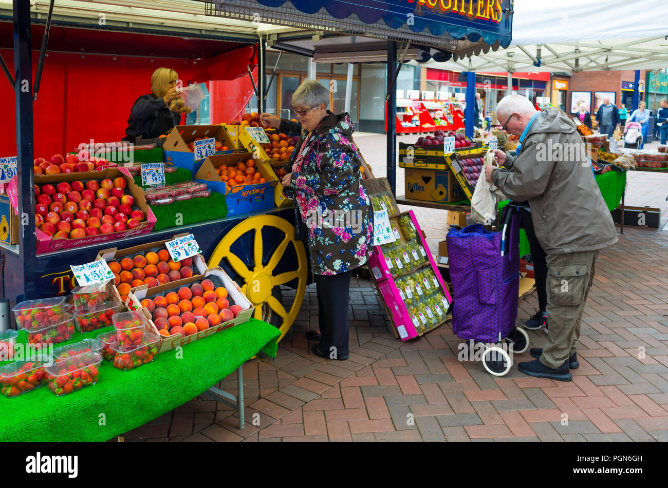 Les clients âgés à un marchand et fruiterers échoppe de marché dans le centre-ville de Redcar Banque D'Images