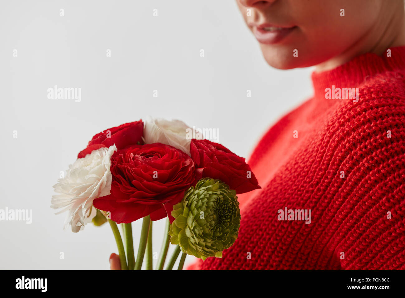 Femme dans un sweat rouge Renoncule à fleurs sur fond blanc Photo Stock -  Alamy