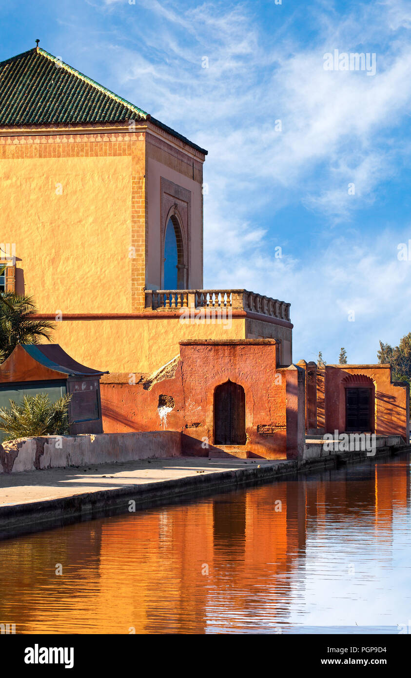 Beaux jardins de la Menara Marrakech Maroc bâtiments avec reflets dans la piscine. Orange, Jaune plâtre avec des toits de tuiles vertes, des arches. Close up. Banque D'Images