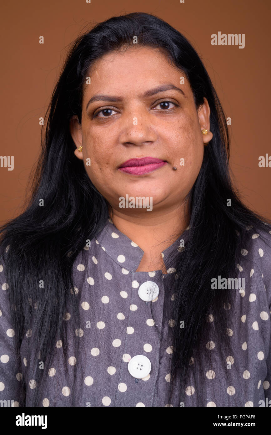 Portrait of mature femme indienne contre fond brun Banque D'Images