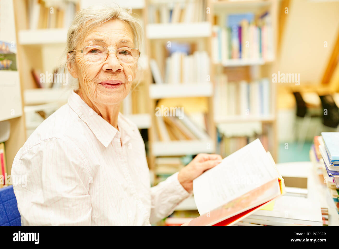 Professeur principal à la retraite ou le bibliothécaire avec réserve dans une bibliothèque Banque D'Images