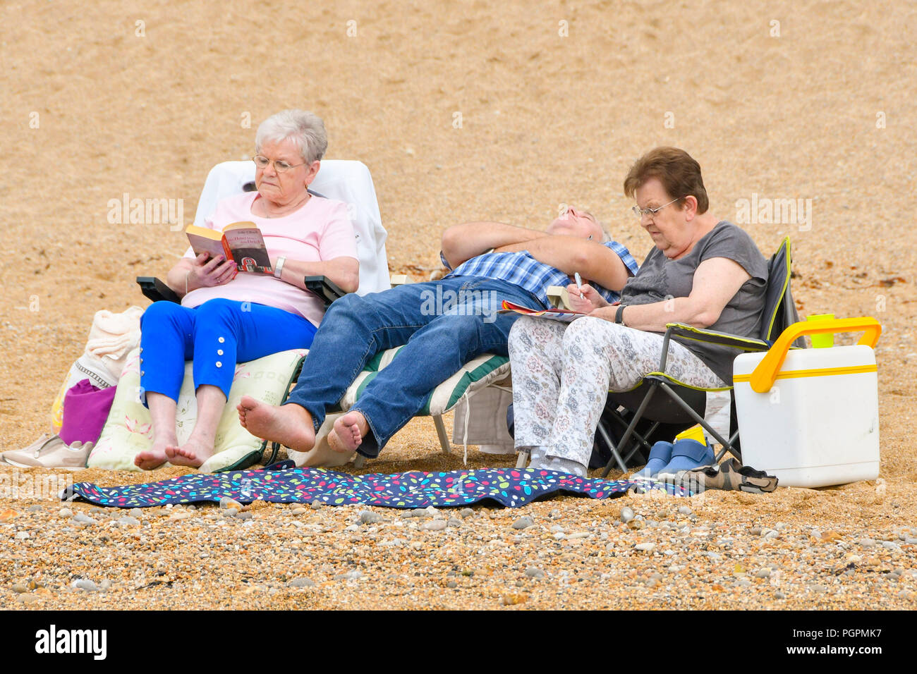 West Bay, Dorset, UK. 28 août 2018. Météo britannique. Les vacanciers sur la plage à la station balnéaire de West Bay dans le Dorset bénéficiant d'un accueil chaleureux, mais surtout jour nuageux. Crédit photo : Graham Hunt/Alamy Live News Banque D'Images