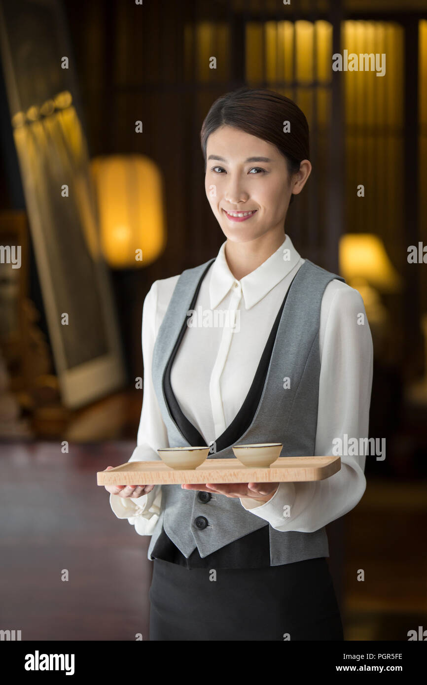 L'élégance waitress holding deux tasses de thé Banque D'Images