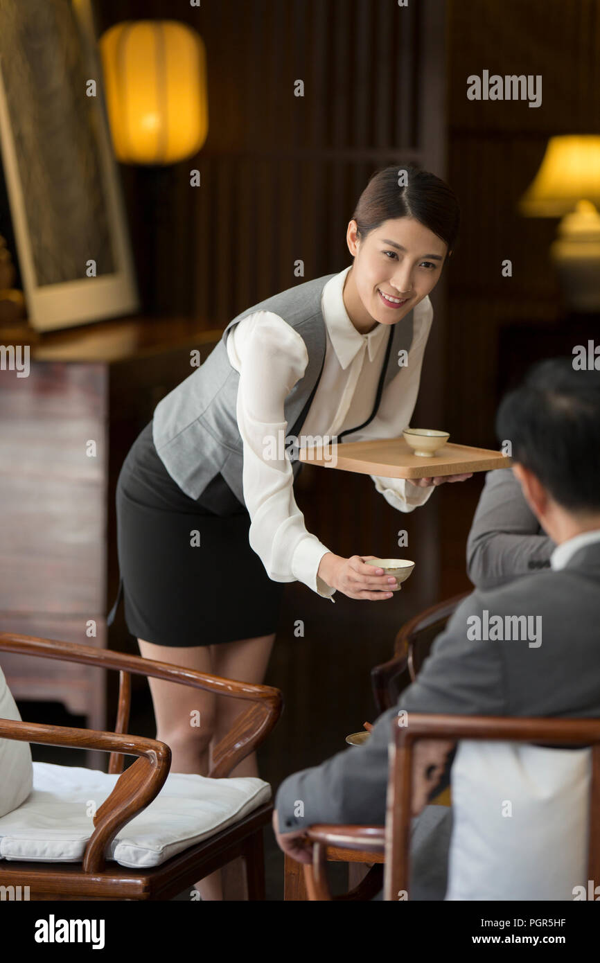 L'élégance waitress holding deux tasses de thé Banque D'Images