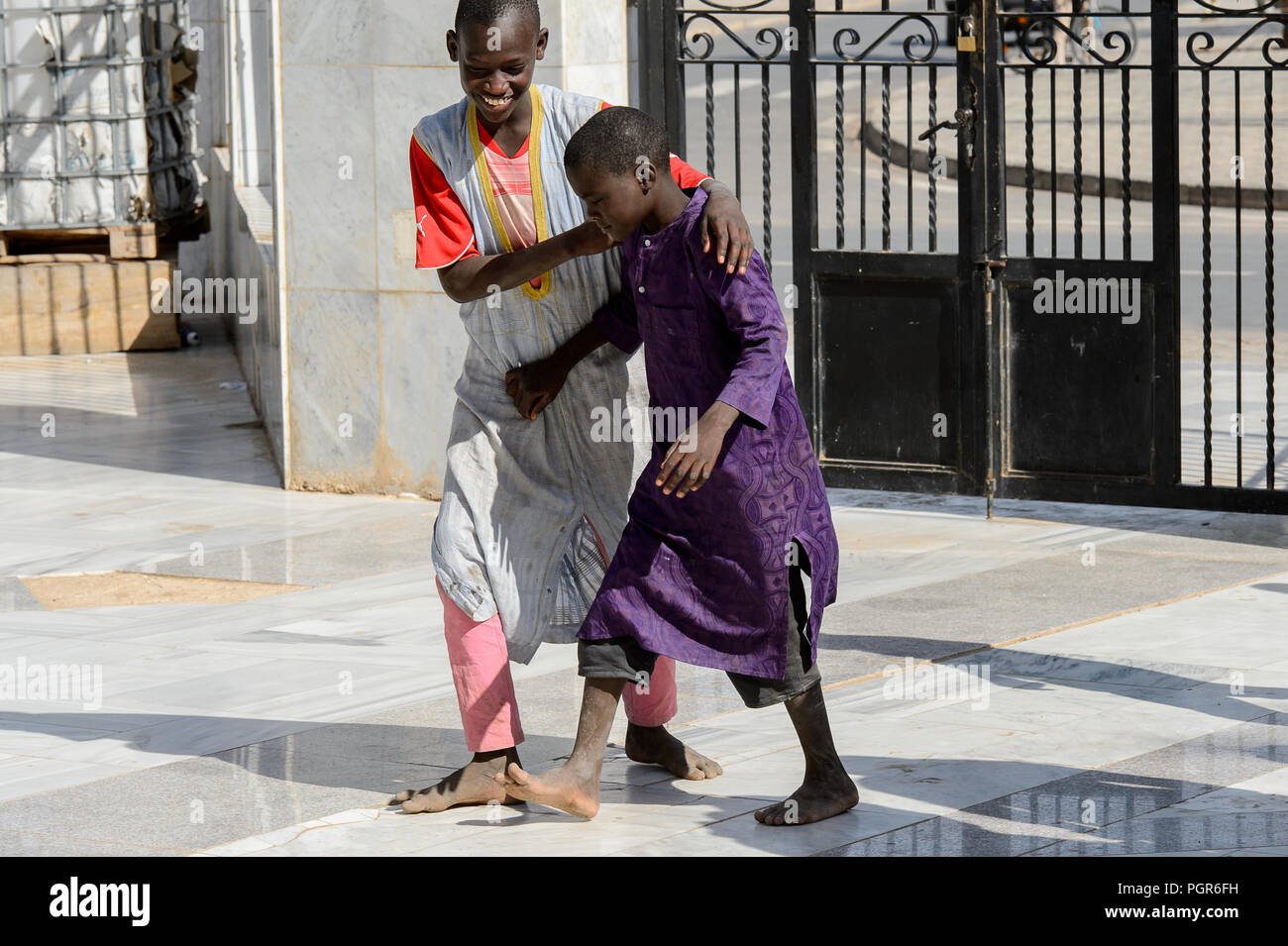 TOUBA, SÉNÉGAL - 26 avr 2017 : garçons sénégalais non identifiés en vêtements traditionnels à pied dans la Grande Mosquée de Touba, l'accueil de la confrérie Mouride Brotherh Banque D'Images
