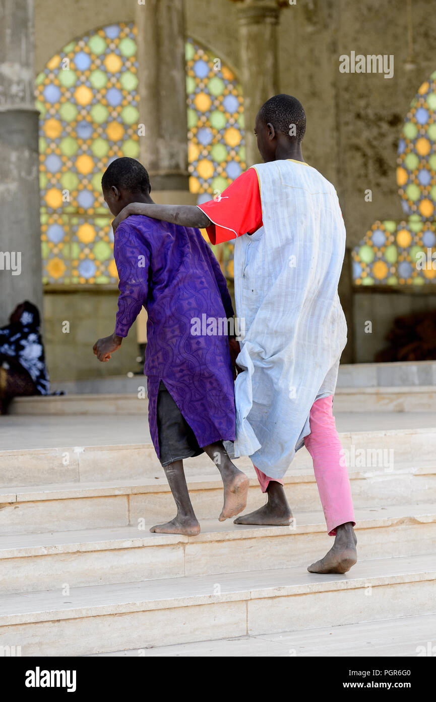 TOUBA, SÉNÉGAL - 26 avr 2017 : garçons sénégalais non identifiés en vêtements traditionnels à pied dans la Grande Mosquée de Touba, l'accueil de la confrérie Mouride Brotherh Banque D'Images