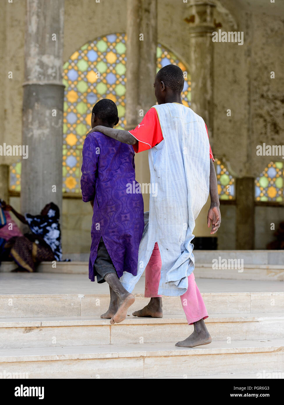 TOUBA, SÉNÉGAL - 26 avr 2017 : garçons sénégalais non identifiés en vêtements traditionnels à pied dans la Grande Mosquée de Touba, l'accueil de la confrérie Mouride Brotherh Banque D'Images